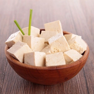 Tofu cubes in wooden bowl