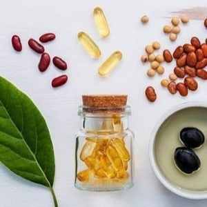 Glass with vitamin capsules and leaf