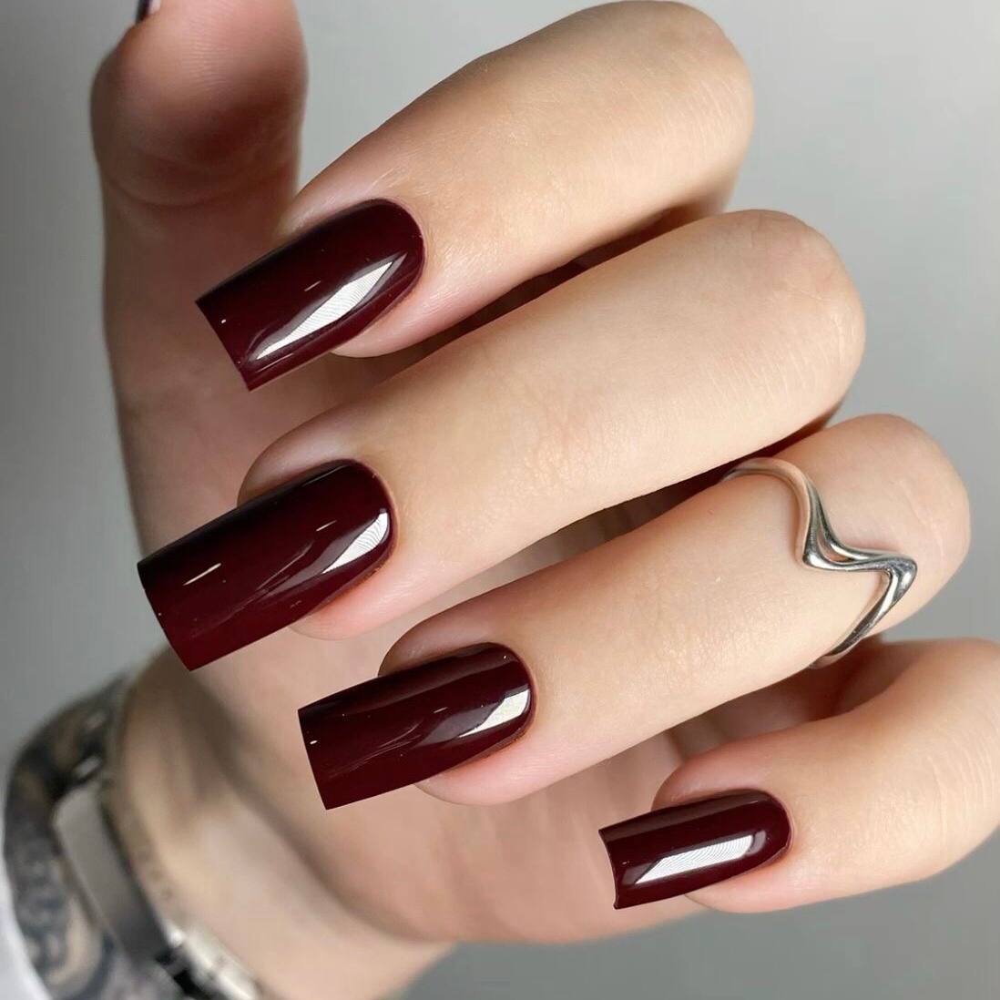 Bordeauxfarbene Herbstmaniküre auf quadratischen Nägeln